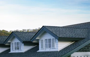 Gray shingle roof with two white dormers