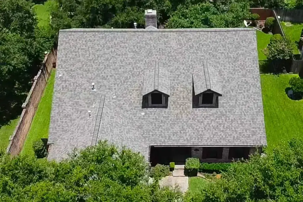 Aerial view of a gray shingle roof with two dormers