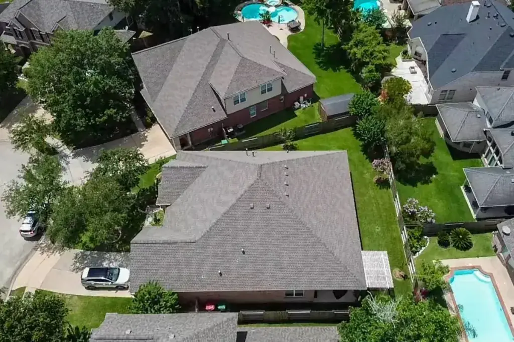 Aerial view of a gray shingle roof in a neighborhood