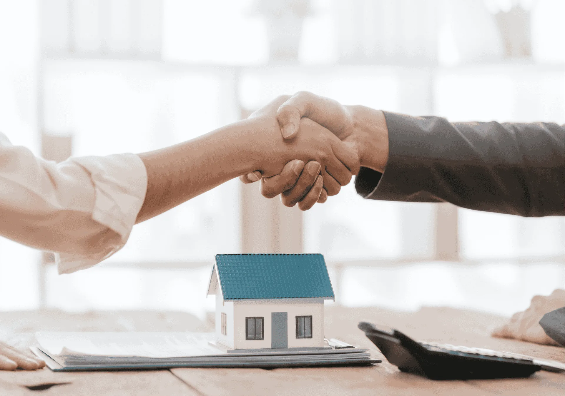 Handshake over a small model house