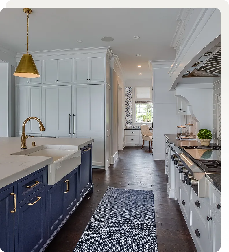 Kitchen with a navy island, gold fixtures, and white cabinets